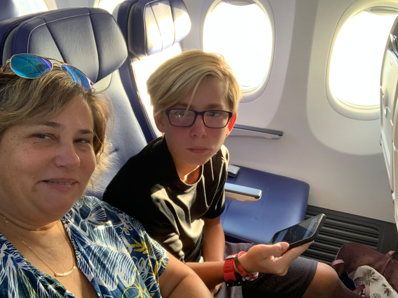 Mother and son in airplane seats, inflight to Hawaii